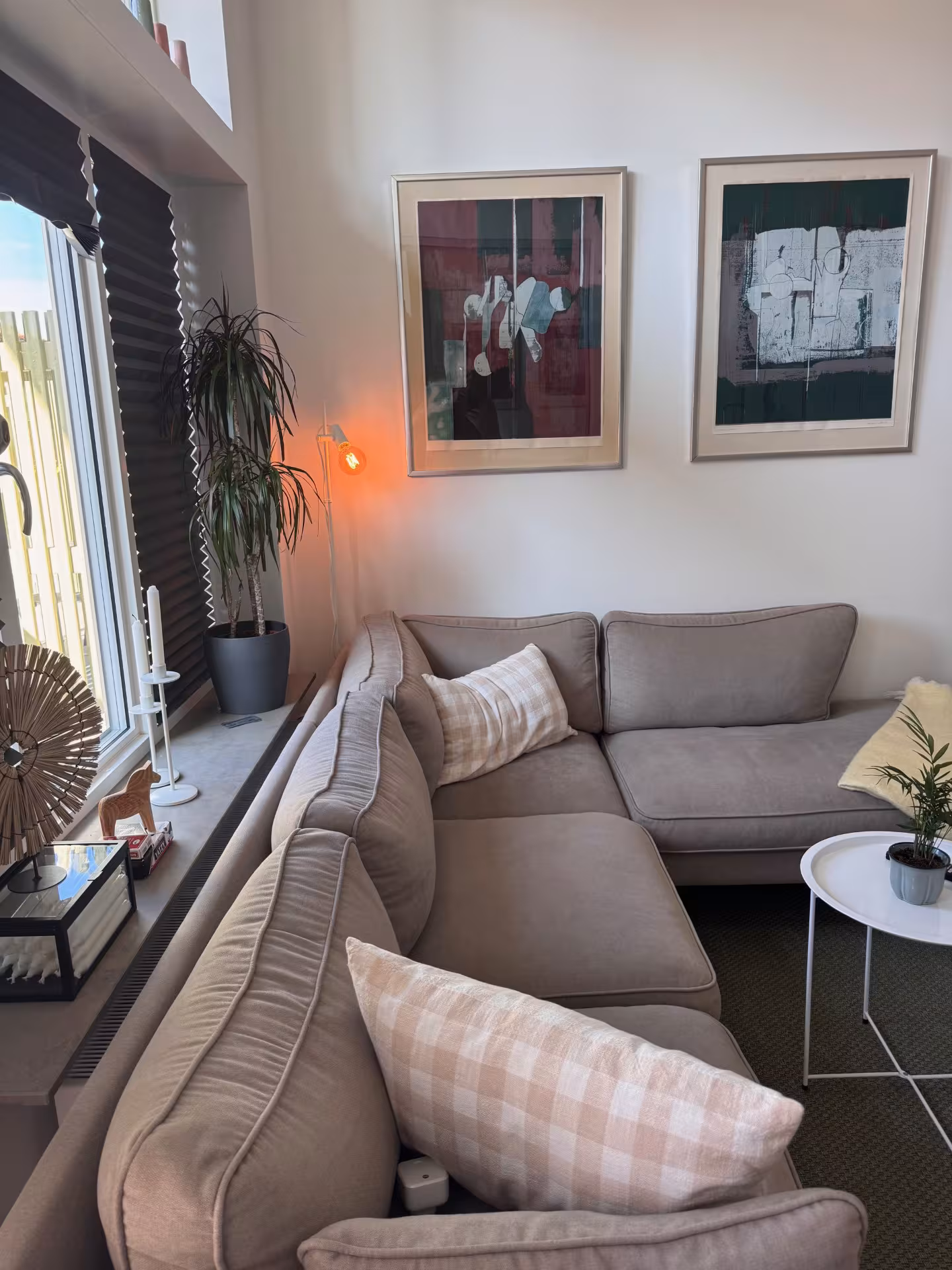 Corner sofa with cushions and artwork