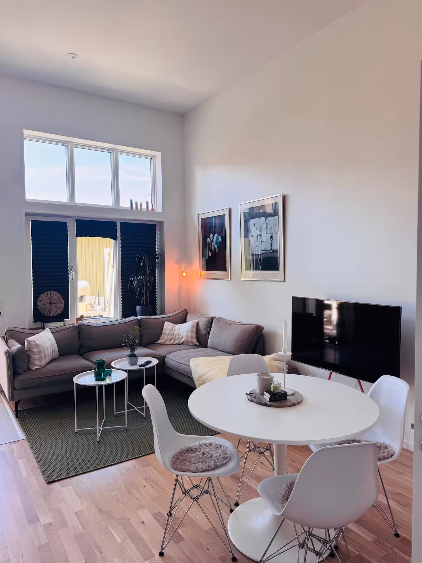 Living room with corner sofa, dining table and large windows