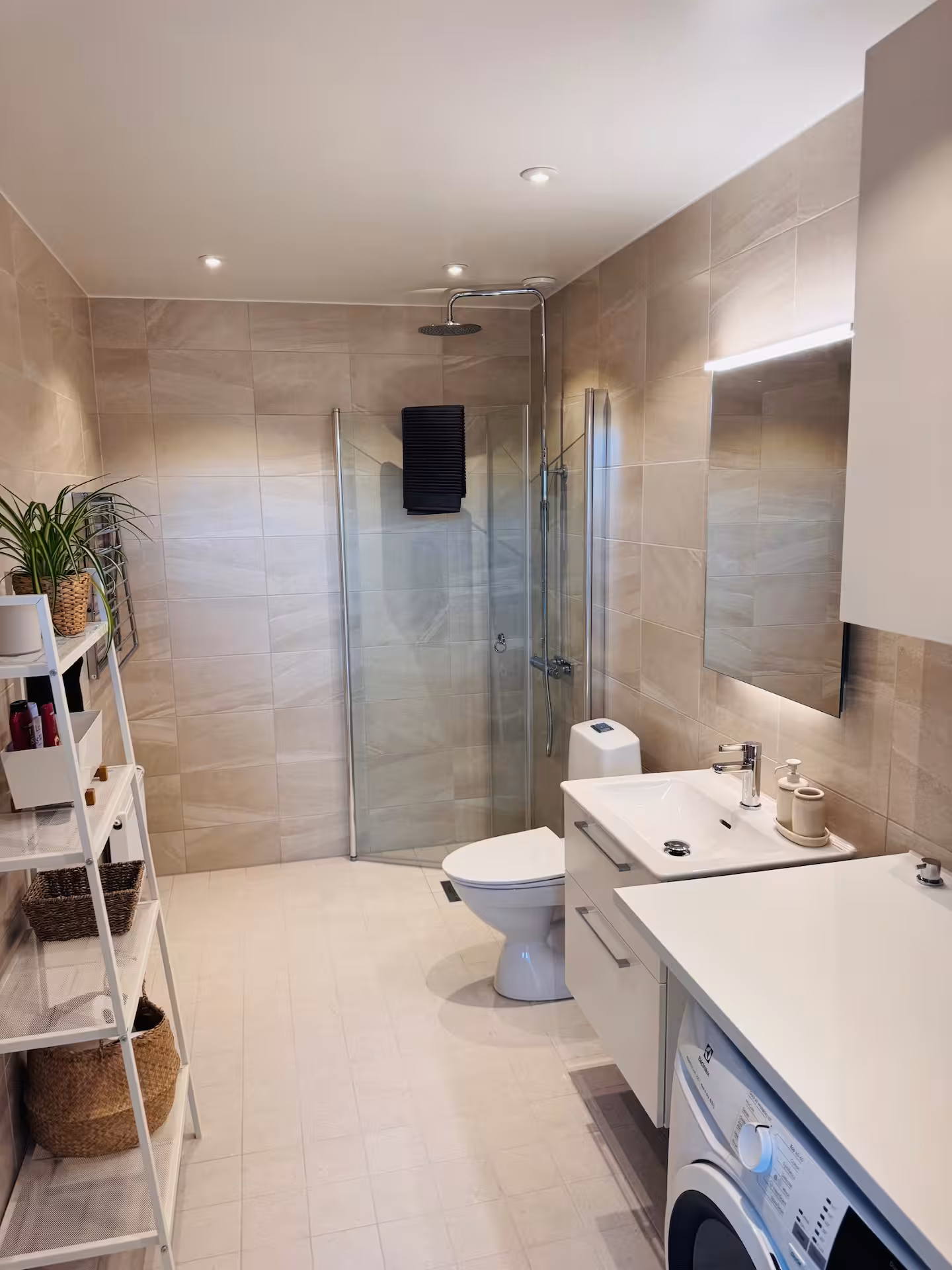 Tiled bathroom with walk-in shower and washing machine